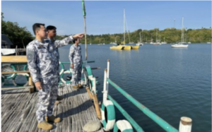 Commodore Christopher Auro (left), commander of the Coast Guard District Southern Visayas, checks on yachts anchored in Tambobo Bay, Siaton, Negros Oriental